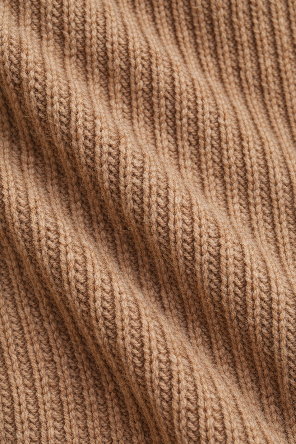 Detailfoto van de gebreide stof van de jurk in camel