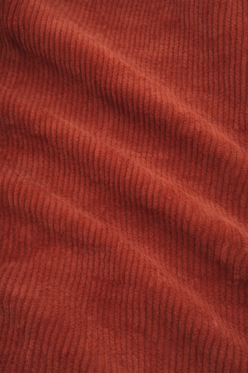 Detailfoto van de ribfluwelen stof in roestbruin