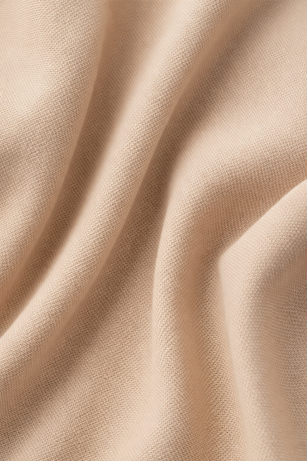 Detailfoto van de soepele stof van de blazer in camel