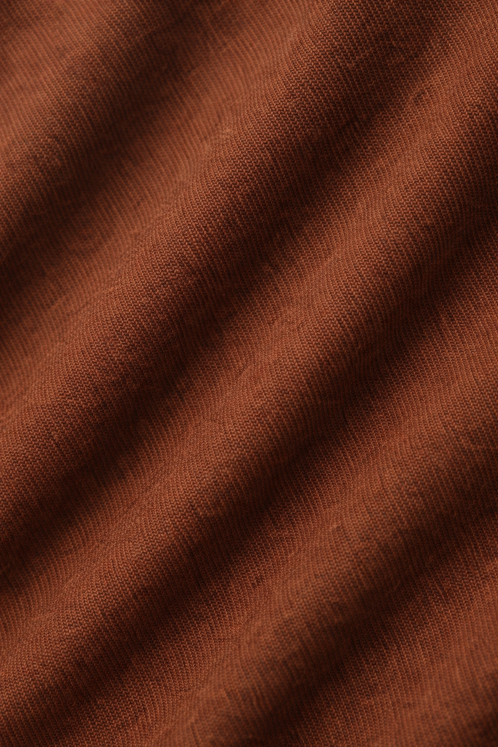 Detailfoto van de soepele stof van de pantalon in donkerbruin